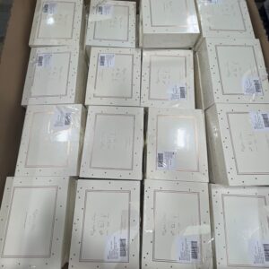 A diverse collection of new, name-brand knit baby gift sets on a wholesale pallet.