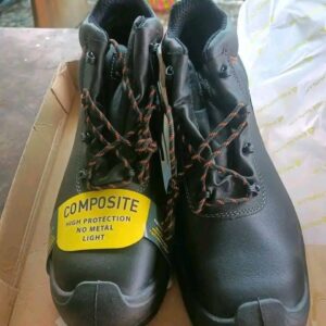 A large pallet stacked high with various pairs of work boots, ready for bulk purchase.