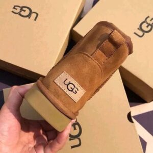 A large pallet stacked with numerous boxed Ugg shoes, showcasing a variety of styles and sizes.