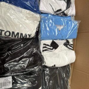 Large stack of Amazon clothing return pallets filled with assorted apparel