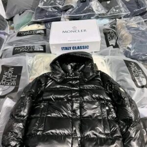 A large pallet stacked with new, authentic Moncler jacket pallets in sealed packaging.